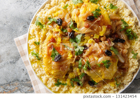 Chicken Couscous Tfaya With Caramelized Onion and Raisin closeup on the plate. Horizontal top view Chicken Couscous Tfaya With Caramelized Onion and Raisin closeup on the plate. Horizontal top view 131423454