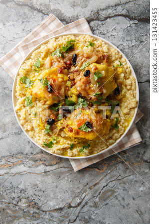Savory sweet fragrant chicken couscous tfaya is a comforting and special meal closeup on the plate. Vertical top view Savory sweet fragrant chicken couscous tfaya is a comforting and special meal closeup on the plate. Vertical top view 131423455