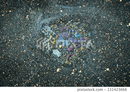 Oil spill forming a colorful, iridescent pattern on a wet asphalt surface, symbolizing pollution Oil spill forming a colorful, iridescent pattern on a wet asphalt surface, symbolizing pollution 131423666