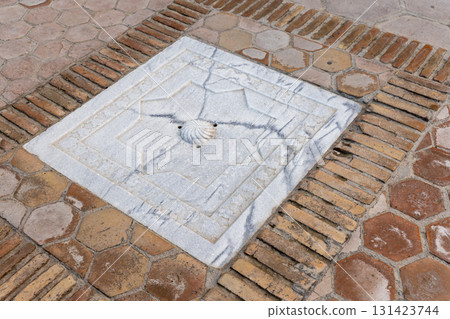 A decorative square drainage cover embedded in a paved brick walkway A decorative square drainage cover embedded in a paved brick walkway 131423744