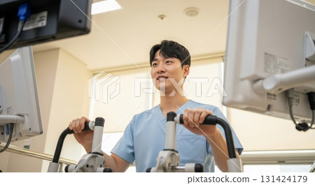 Asian male healthcare professional operating advanced medical imaging equipment in modern hospital radiology department Asian male healthcare professional operating advanced medical imaging equipment in modern hospital radiology department 131424179