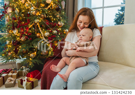 Merry Christmas Xmas. Happy family mother newborn baby child hugging bonding near Christmas tree at home. Mom girl kid celebrating Christmas New Year enjoying winter holidays together. Family moments Merry Christmas Xmas. Happy family mother newborn baby child hugging bonding near Christmas tree at home. Mom girl kid celebrating Christmas New Year enjoying winter holidays together. Family moments 131424230