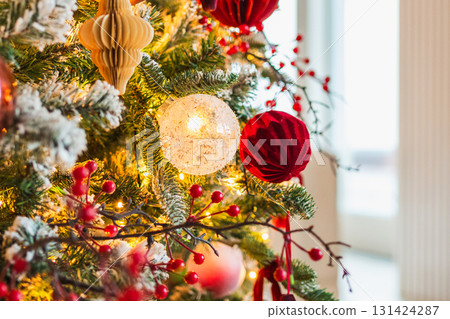 Merry Christmas Xmas happy holidays. Golden ornament decoration ball and defocused garland lights on classic decorated Christmas tree. Christmas tree with red white ornaments. Christmas eve at home 131424287