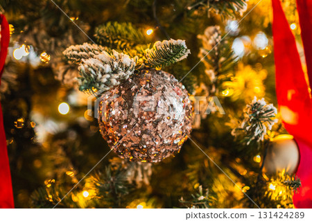 Merry Christmas Xmas happy holidays. Golden ornament decoration ball and defocused garland lights on classic decorated Christmas tree. Christmas tree with red white ornaments. Christmas eve at home Merry Christmas Xmas happy holidays. Golden ornament decoration ball and defocused garland lights on classic decorated Christmas tree. Christmas tree with red white ornaments. Christmas eve at home 131424289