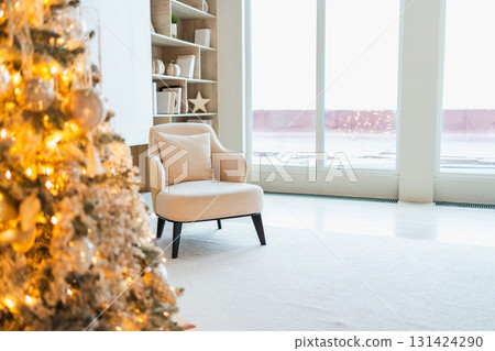 Classical Christmas decorated interior living room. Modern classic style interior design apartment with cozy chair and Christmas tree with white golden ornament decorations. Christmas eve at home Classical Christmas decorated interior living room. Modern classic style interior design apartment with cozy chair and Christmas tree with white golden ornament decorations. Christmas eve at home 131424290