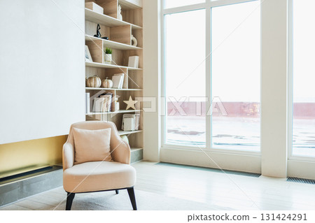 Stylish loft living room interior. Spacious design apartment with light white walls large window beige chair armchair. Clean modern decoration with elegant furniture in minimalist Scandinavian style Stylish loft living room interior. Spacious design apartment with light white walls large window beige chair armchair. Clean modern decoration with elegant furniture in minimalist Scandinavian style 131424291