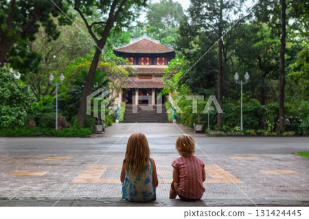 Children sitting near Vietnamese temple in Saigon 131424445