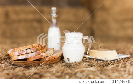 milk in a jug, slices of wheat bread and butter on hay milk in a jug, slices of wheat bread and butter on hay 131424688
