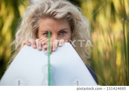 Stylish blonde surfing girl holding white surfboard in jungle on Bali. Close-up woman portrait, perfect for exotic travel content, freedom lifestyle, surf destinations in tropical islands destinations Stylish blonde surfing girl holding white surfboard in jungle on Bali. Close-up woman portrait, perfect for exotic travel content, freedom lifestyle, surf destinations in tropical islands destinations 131424695
