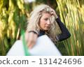 Stylish blonde surfing girl holding white surfboard in jungle on Bali. Close-up woman portrait, perfect for exotic travel content, freedom lifestyle, surf destinations in tropical islands destinations 131424696