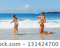 Mother, daughter playing together on beach, enjoying waves and warm summer day. Family vacation fun by ocean with kids. White sand, turquoise sea. Travel lifestyle, summer holiday, beach destinations 131424700