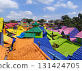 Aerial view of vibrant rooftops in Kampung Warna Warni Jodipan, Malang, East Java, Indonesia. Famous rainbow village, perfect destination for urban tourism, travel blogging, and cultural exploration. 131424705