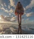 A high school girl in uniform walking along the beach at dusk 131425116