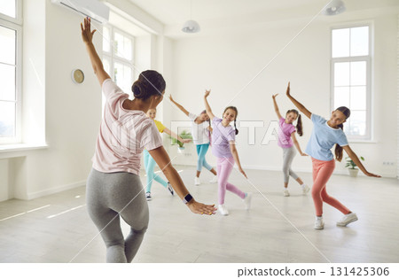 Group of happy children dancers having a dance class with a choreography teacher Group of happy children dancers having a dance class with a choreography teacher 131425306