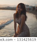 A woman in a dress standing by the sea 131425619