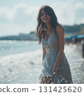 A woman in a dress standing by the sea 131425620