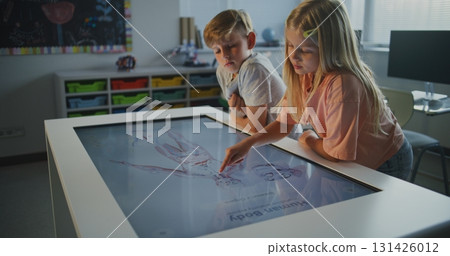 Schoolchildren Collaborate at Touchscreen, Examining Human Anatomy Schoolchildren Collaborate at Touchscreen, Examining Human Anatomy 131426012