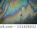 Asphalt road showing colorful oil slick creating an abstract iridescent texture 131426032