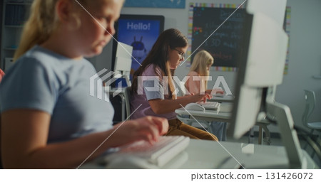 Young Girl Typing on Computer Keyboard in Sunlit Classroom Young Girl Typing on Computer Keyboard in Sunlit Classroom 131426072