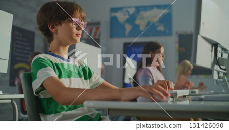 Young Student Striped T-shirt Working at Computer in Bright Classroom 131426090