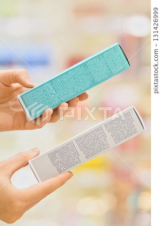 Woman selecting a cosmetic serum for face or hair in a beauty store, reading ingredients, comparing products. Female customer holding skincare or haircare item. Concept of conscious choice, self-care Woman selecting a cosmetic serum for face or hair in a beauty store, reading ingredients, comparing products. Female customer holding skincare or haircare item. Concept of conscious choice, self-care 131426999