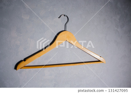 Wooden clothes hanger with metal hook. Concept of simplicity and home organization 131427095