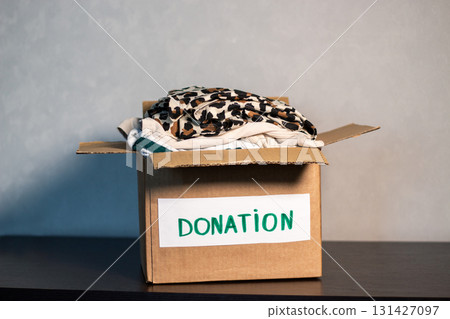 Woman preparing old clothes for charity. Clothes donation concept. Second hand shop. 131427097
