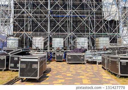 Boxes with concert equipment against a blurred stage. Preparing for a concert. 131427770