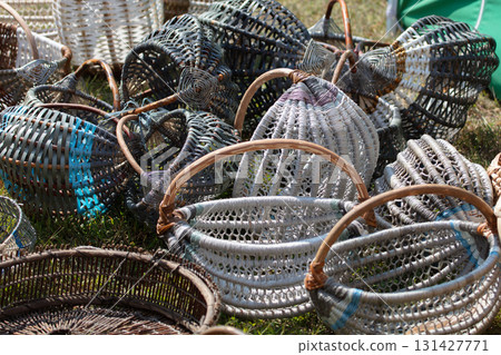 Wicker baskets at a craft fair. There are many of them, all piled up. 131427771