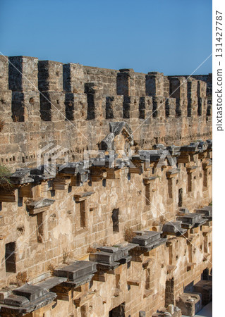 Part of the stone wall of the ancient amphitheater with architectural elements. Part of the stone wall of the ancient amphitheater with architectural elements. 131427787