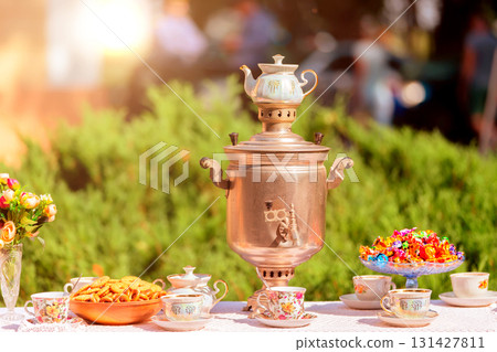 Traditional Russian samovar with cups and sweets on the table. Traditional Russian samovar with cups and sweets on the table. 131427811