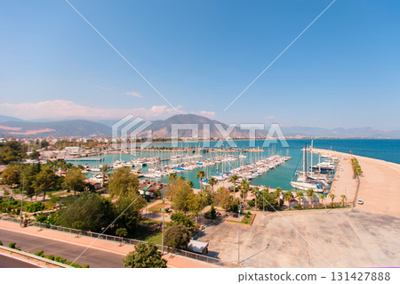 Coastal city view from above. Embankment with yachts and bay. Mountains are visible in the distance. 131427888