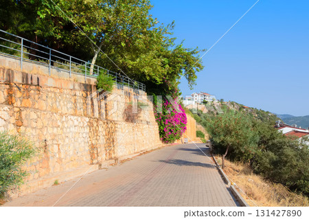 The road to the Turkish city along a stone wall with a flower vine. The road to the Turkish city along a stone wall with a flower vine. 131427890