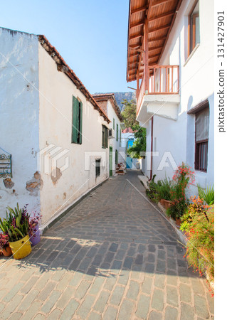 Narrow tourist streets of the Turkish city of Kas with white houses and colored windows. Beautiful ethnic resort town. Narrow tourist streets of the Turkish city of Kas with white houses and colored windows. Beautiful ethnic resort town. 131427901