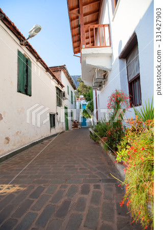 Narrow tourist streets of the Turkish city of Kas with white houses and colored windows. Beautiful ethnic resort town. 131427903