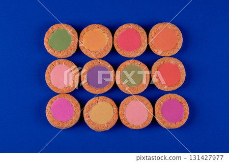 A row of colorful cookies with a blue background. The cookies are in a row and are of different colors A row of colorful cookies with a blue background. The cookies are in a row and are of different colors 131427977