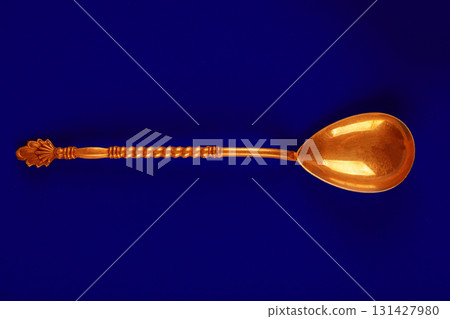 Golden teaspoon on a blue background. Golden teaspoon on a blue background. 131427980