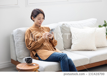 一位中年婦女拿著智慧型手機微笑 131428700