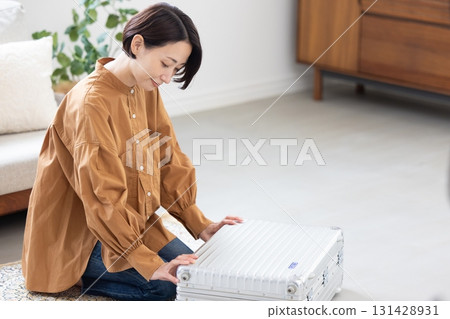 Woman packing clothes into a suitcase Woman packing clothes into a suitcase 131428931