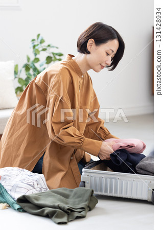 女人把衣服打包放進行李箱 131428934