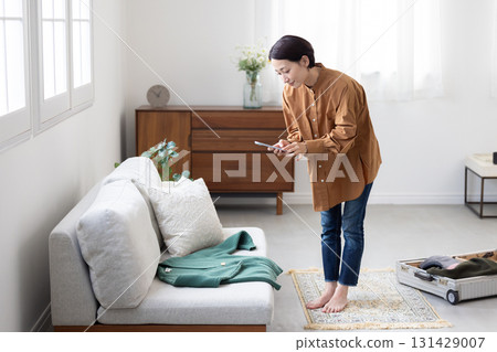 A woman taking a photo of clothes with a smartphone A woman taking a photo of clothes with a smartphone 131429007