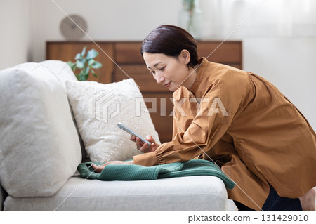 A woman taking a photo of clothes with a smartphone A woman taking a photo of clothes with a smartphone 131429010