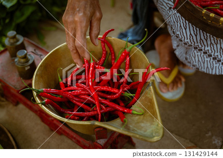 A colorful array of Fresh Red Chilies beautifully arranged in a Market Basket for sale A colorful array of Fresh Red Chilies beautifully arranged in a Market Basket for sale 131429144