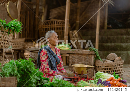 An elderly woman navigating a vibrant market full of fresh vegetables and local produce An elderly woman navigating a vibrant market full of fresh vegetables and local produce 131429145