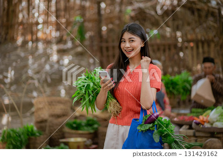A Cheerful Young Woman Enjoys Her Time at a Local Market Filled with Fresh Vegetables 131429162