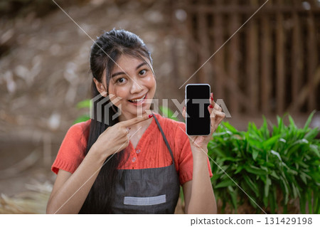 A Young Woman Enthusiastically Holding Her Smartphone in a Beautiful Natural Setting 131429198