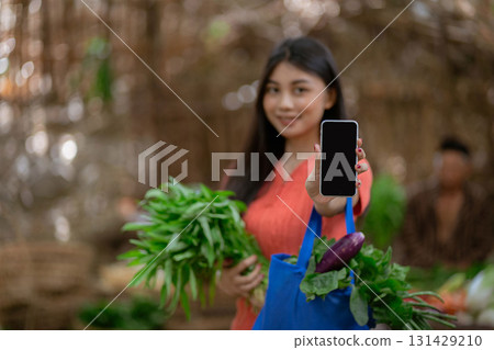 A Young Woman Enthusiastically Shopping for Fresh Vegetables at a Local Market Today 131429210