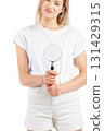 Studio portrait of woman with magnifying glass 131429315