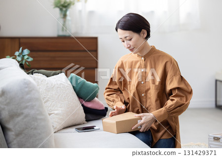 Woman packing headphones into a box Woman packing headphones into a box 131429371