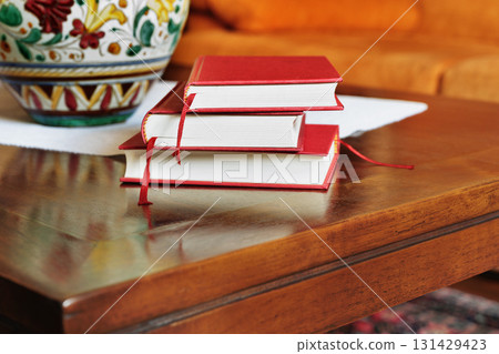 Hardbacked books on wooden table 131429423